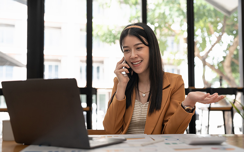 Professional woman smiling while speaking on a phone call