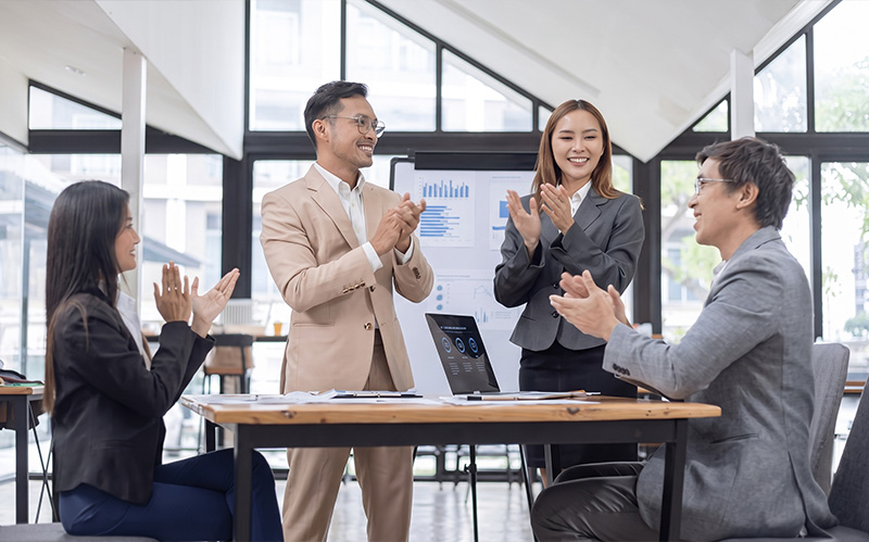 corporate-team-applauding-colleague-during-leadership-meeting
