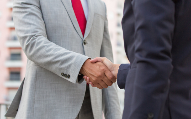 Close-up of business professionals shaking hands after training session