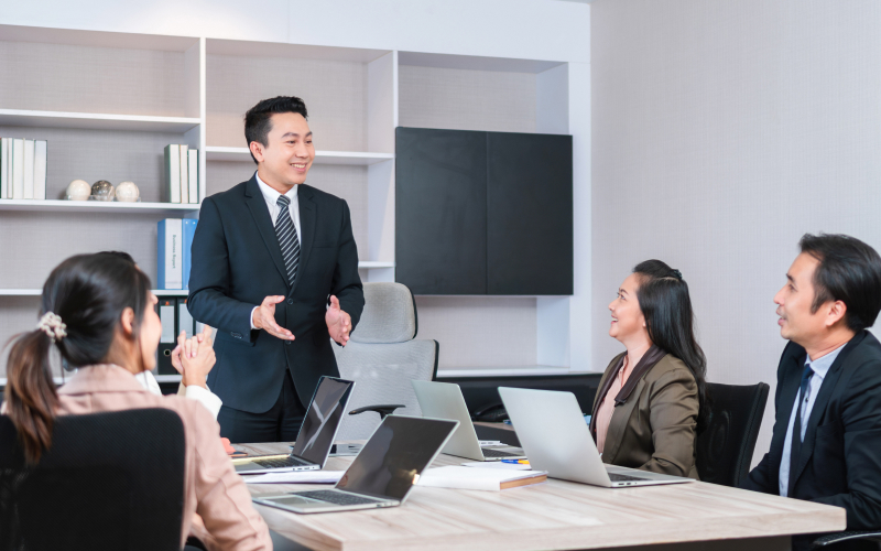 Businessman standing and presenting training outcomes to colleagues
